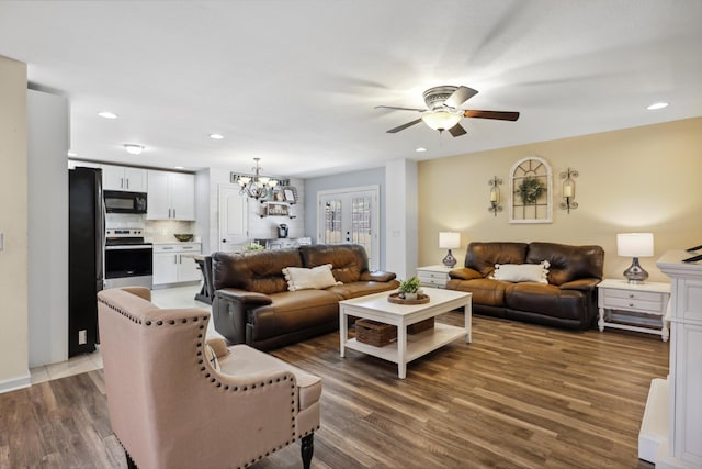 living area with ceiling fan with notable chandelier, recessed lighting, and wood finished floors