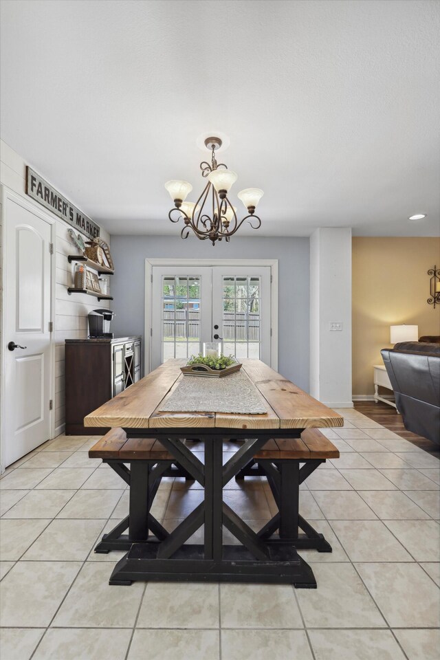 dining room with a chandelier, french doors, baseboards, and light tile patterned floors