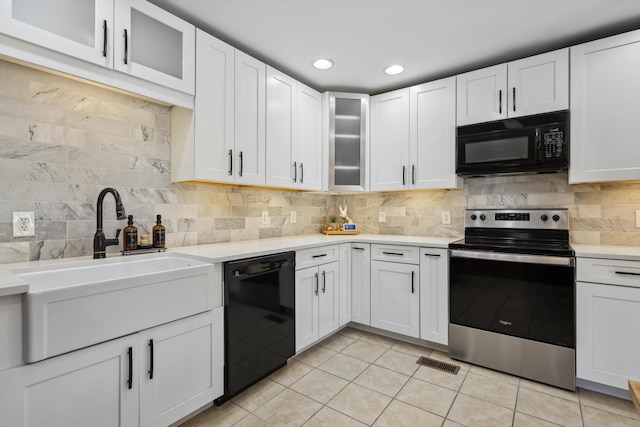 kitchen featuring a sink, white cabinets, light countertops, decorative backsplash, and black appliances