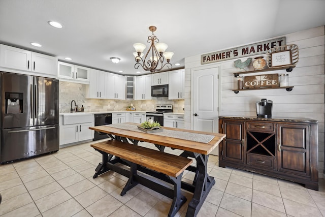 kitchen with tasteful backsplash, glass insert cabinets, white cabinets, light tile patterned flooring, and black appliances