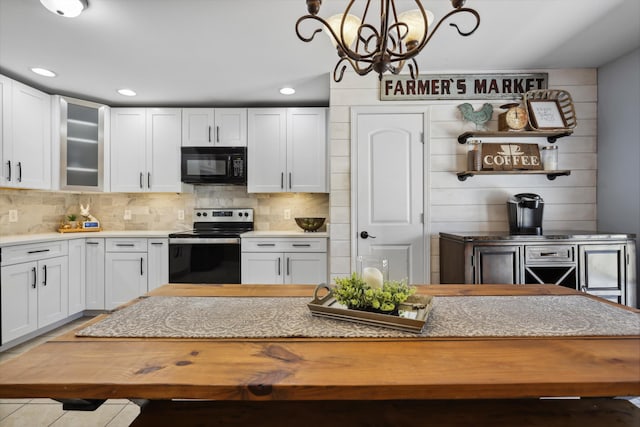 kitchen with stainless steel range with electric stovetop, black microwave, white cabinetry, and decorative backsplash