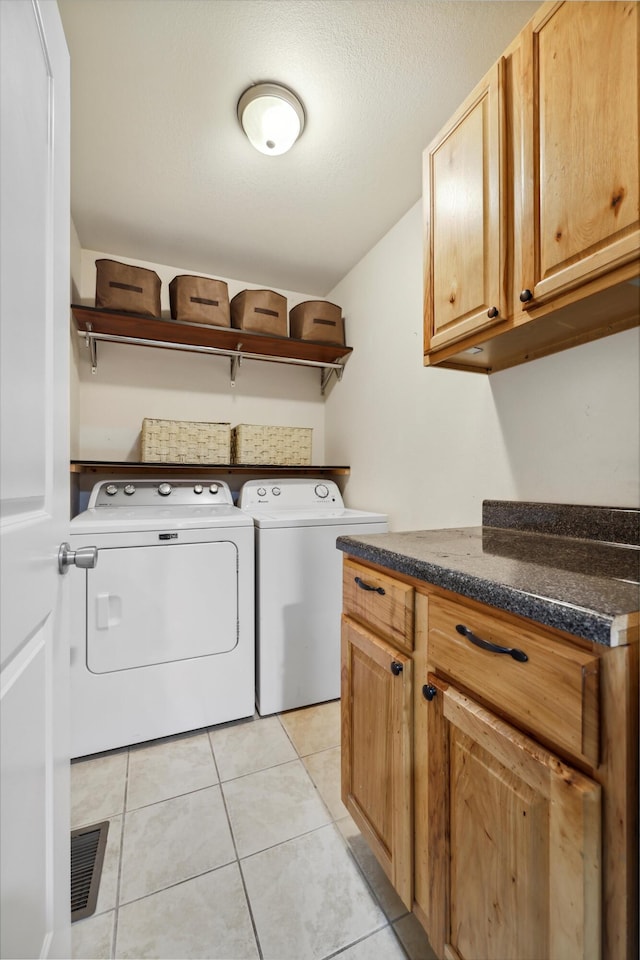 washroom with light tile patterned floors, cabinet space, visible vents, independent washer and dryer, and a textured ceiling