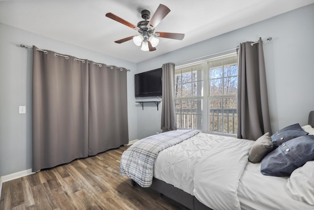 bedroom with ceiling fan, baseboards, and wood finished floors