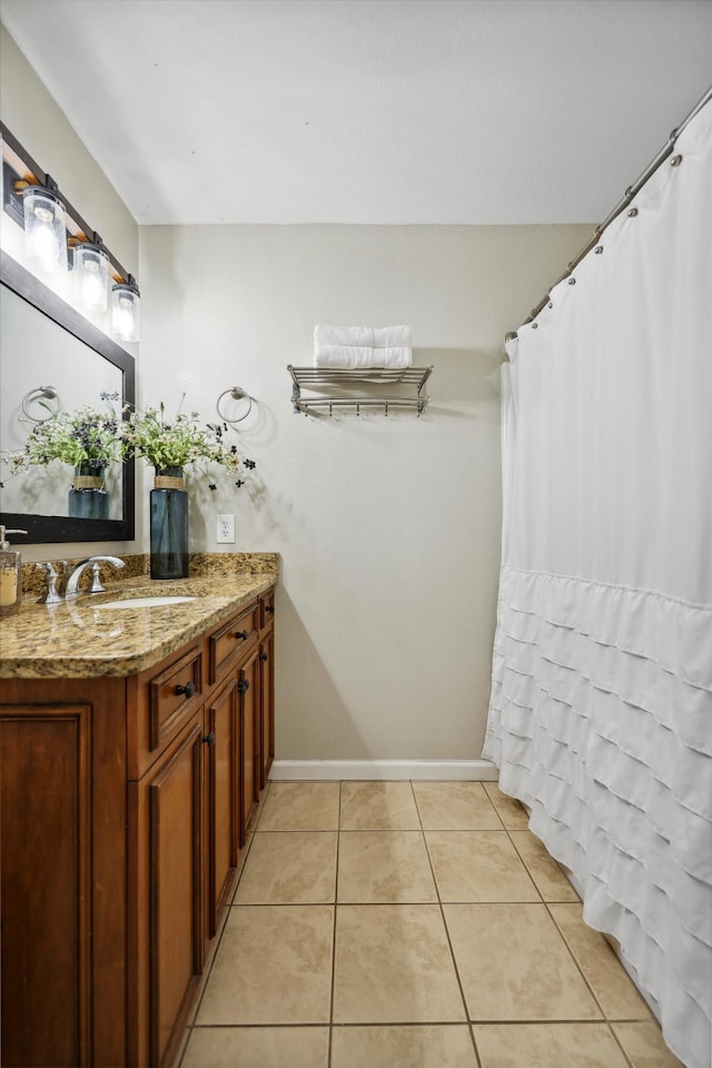 full bath with vanity, baseboards, and tile patterned floors