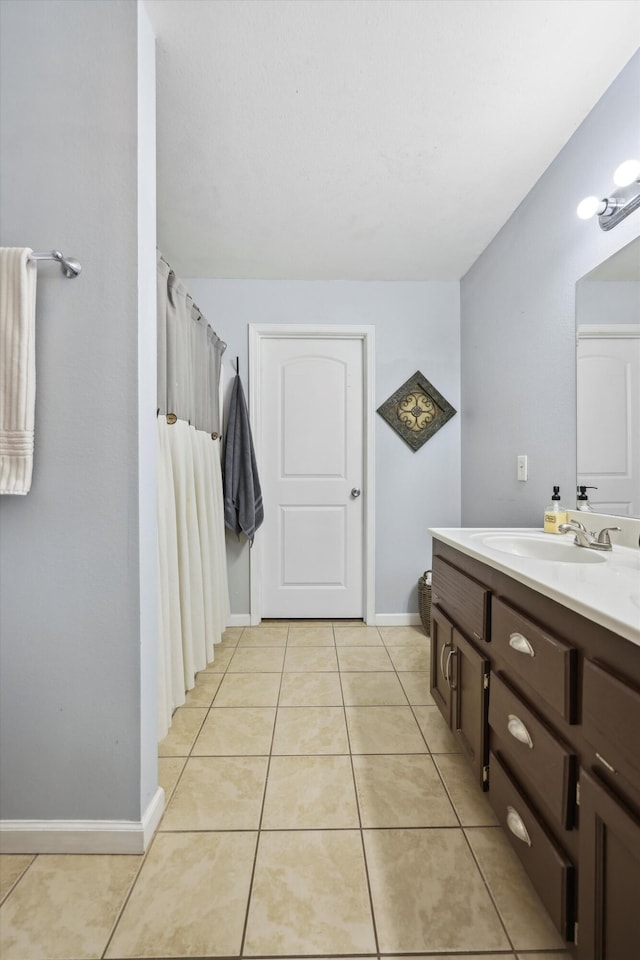 full bath featuring baseboards, a shower with shower curtain, vanity, and tile patterned floors