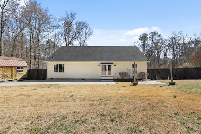 rear view of house with entry steps, french doors, crawl space, fence, and a yard