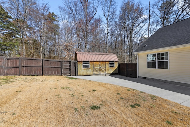 view of yard featuring an outbuilding, a storage shed, and a fenced backyard