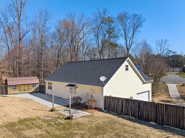 back of property featuring a yard, roof with shingles, and fence