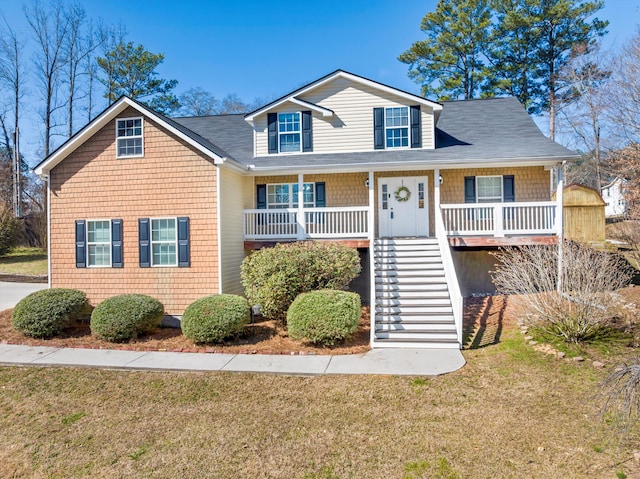 view of front of home featuring stairs, a porch, and a front lawn