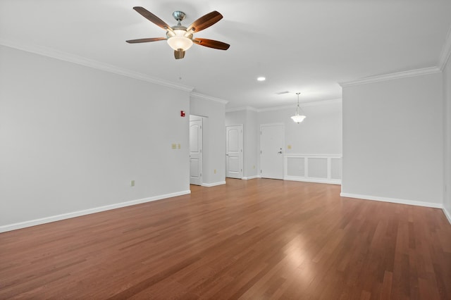 unfurnished living room with ceiling fan, ornamental molding, wood finished floors, and baseboards