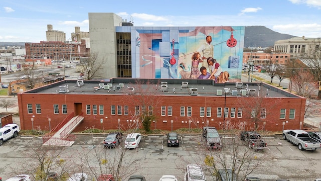 view of property with uncovered parking and a view of city