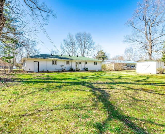 rear view of house with a storage shed, a yard, fence, and an outdoor structure