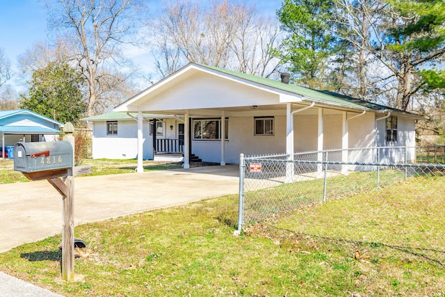 view of front of property with an attached carport, fence, a front lawn, and driveway