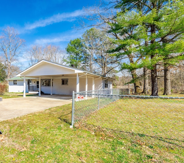 view of front facade featuring stucco siding, a front lawn, driveway, fence, and an attached carport