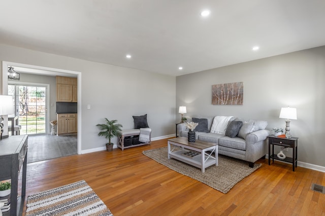 living area with recessed lighting, light wood-style flooring, visible vents, and baseboards