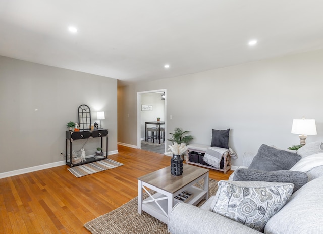 living area with recessed lighting, wood finished floors, and baseboards