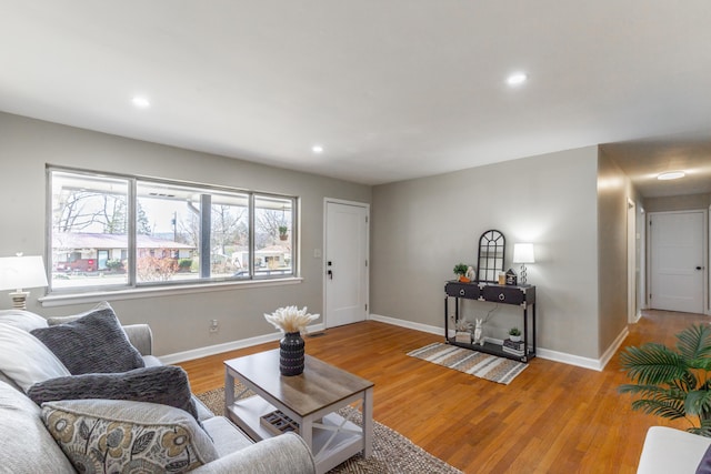 living area with recessed lighting, wood finished floors, and baseboards