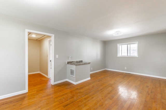 spare room featuring visible vents, baseboards, and light wood-style flooring