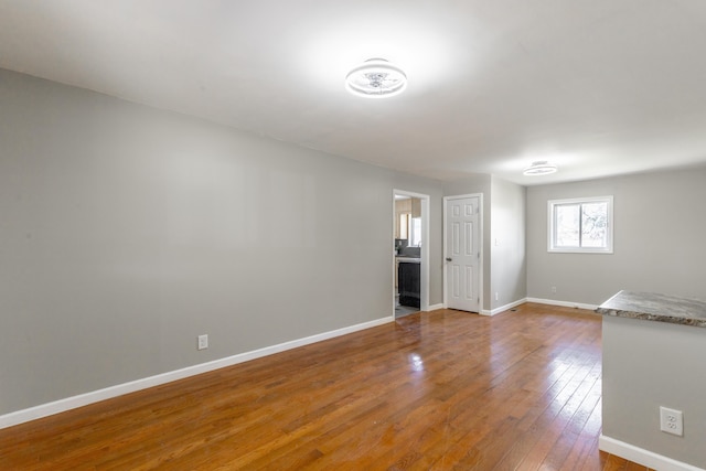 unfurnished room featuring baseboards and wood-type flooring