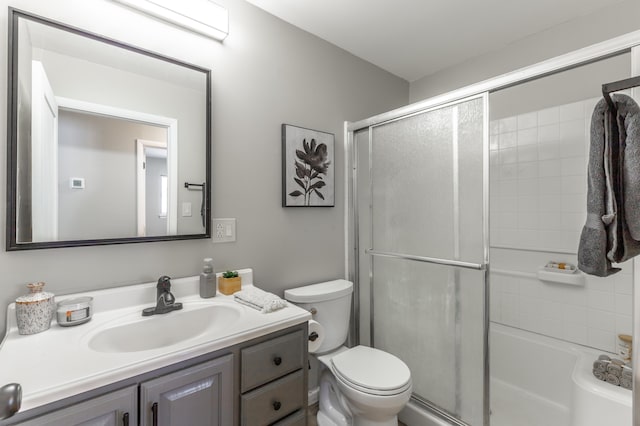 bathroom featuring a shower with shower door, toilet, and vanity