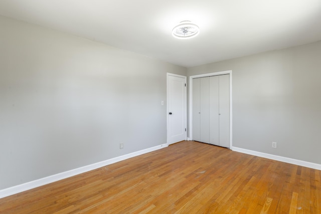 unfurnished room with light wood-style flooring and baseboards