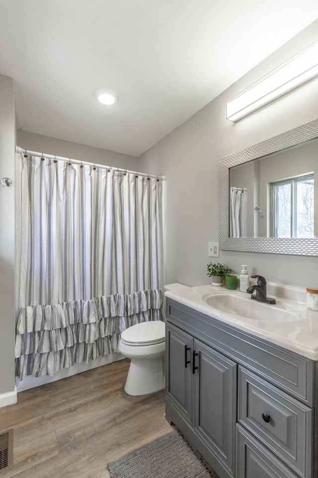 full bathroom featuring vanity, wood finished floors, visible vents, curtained shower, and toilet