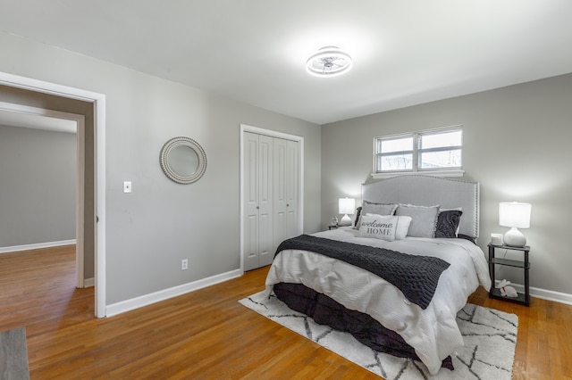 bedroom featuring wood finished floors, baseboards, and a closet