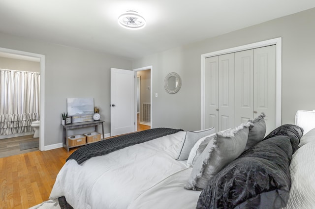 bedroom with light wood-type flooring, visible vents, a closet, connected bathroom, and baseboards