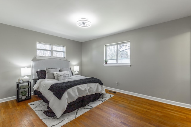 bedroom featuring visible vents, baseboards, and hardwood / wood-style floors