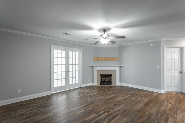 unfurnished living room featuring ornamental molding, baseboards, dark wood-style flooring, and a tile fireplace