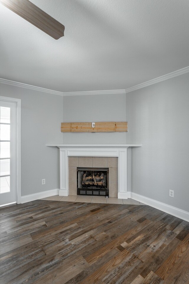 unfurnished living room with dark wood finished floors, a fireplace, and crown molding