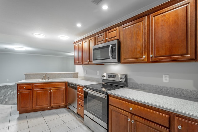 kitchen featuring a peninsula, light tile patterned flooring, a sink, stainless steel appliances, and light countertops