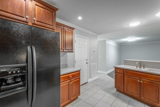 kitchen with crown molding, light countertops, light tile patterned floors, black refrigerator with ice dispenser, and a sink