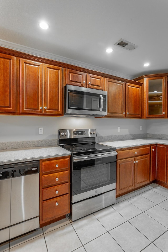 kitchen featuring light tile patterned floors, brown cabinetry, visible vents, recessed lighting, and appliances with stainless steel finishes