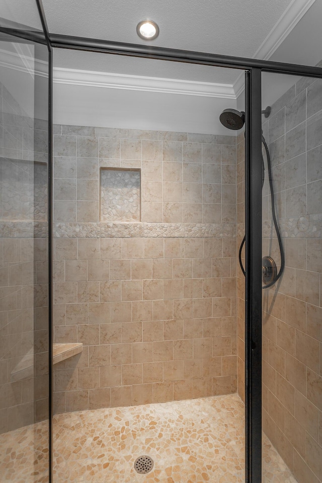 bathroom with ornamental molding and a shower stall