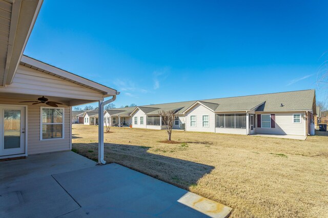 view of yard featuring a residential view, a patio, ceiling fan, and a sunroom