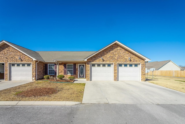 ranch-style home featuring a garage, concrete driveway, and fence