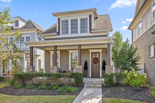 view of front of home featuring covered porch and a shingled roof