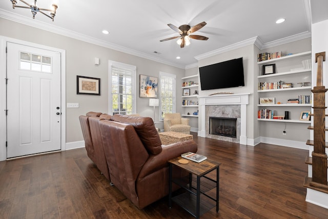 living area with dark wood-type flooring, ornamental molding, baseboards, and ceiling fan