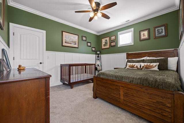 bedroom featuring crown molding, visible vents, carpet flooring, and wainscoting