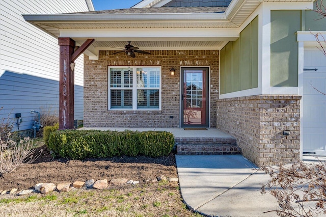 entrance to property featuring a garage, ceiling fan, a shingled roof, and brick siding