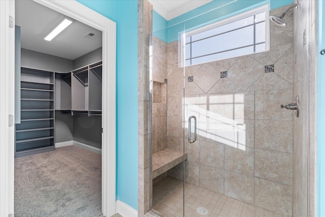 full bath featuring a stall shower, visible vents, a spacious closet, and baseboards