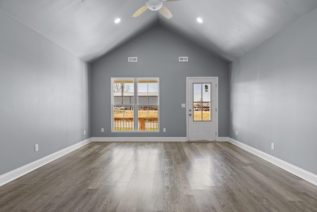 empty room featuring dark wood-style floors, visible vents, a ceiling fan, high vaulted ceiling, and baseboards