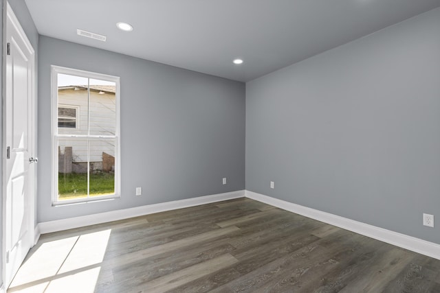 empty room featuring baseboards, visible vents, dark wood finished floors, and recessed lighting