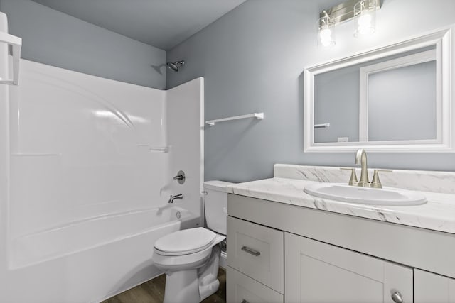 bathroom featuring washtub / shower combination, vanity, toilet, and wood finished floors