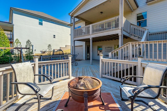 wooden terrace featuring stairway and an outdoor fire pit