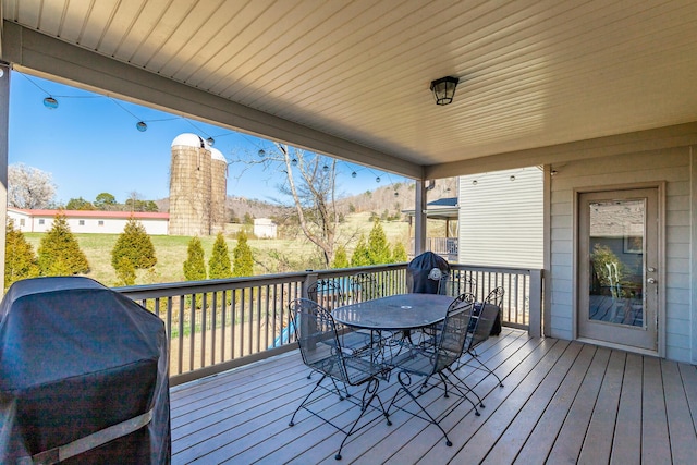 wooden deck featuring a grill and outdoor dining area