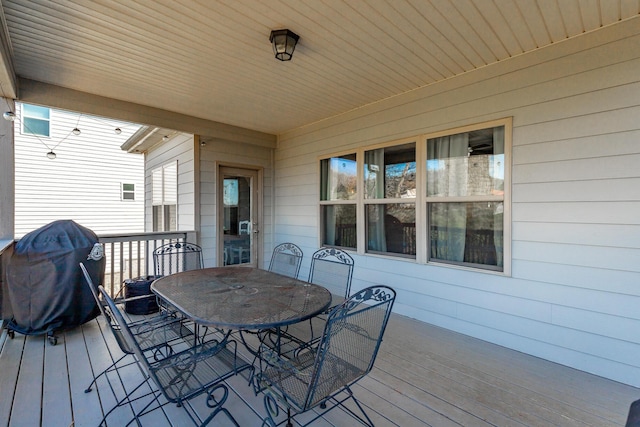 wooden terrace featuring outdoor dining space and area for grilling