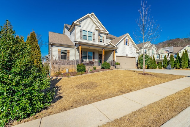 craftsman-style house with a porch, an attached garage, a front lawn, and driveway