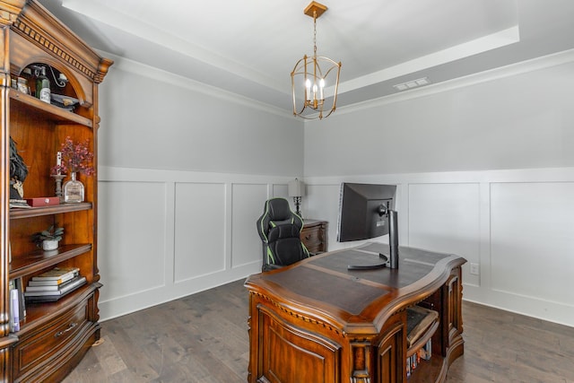 office with visible vents, dark wood finished floors, a decorative wall, a raised ceiling, and a chandelier